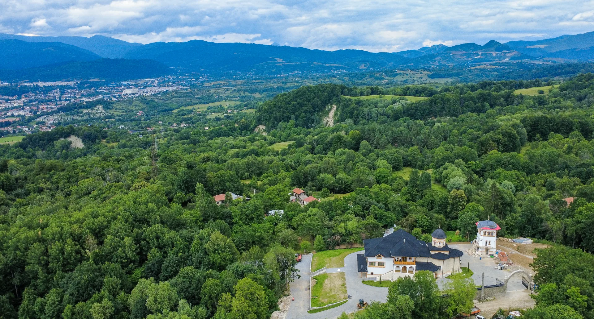 Vedere aeriana a schitului cu muntii in fundal