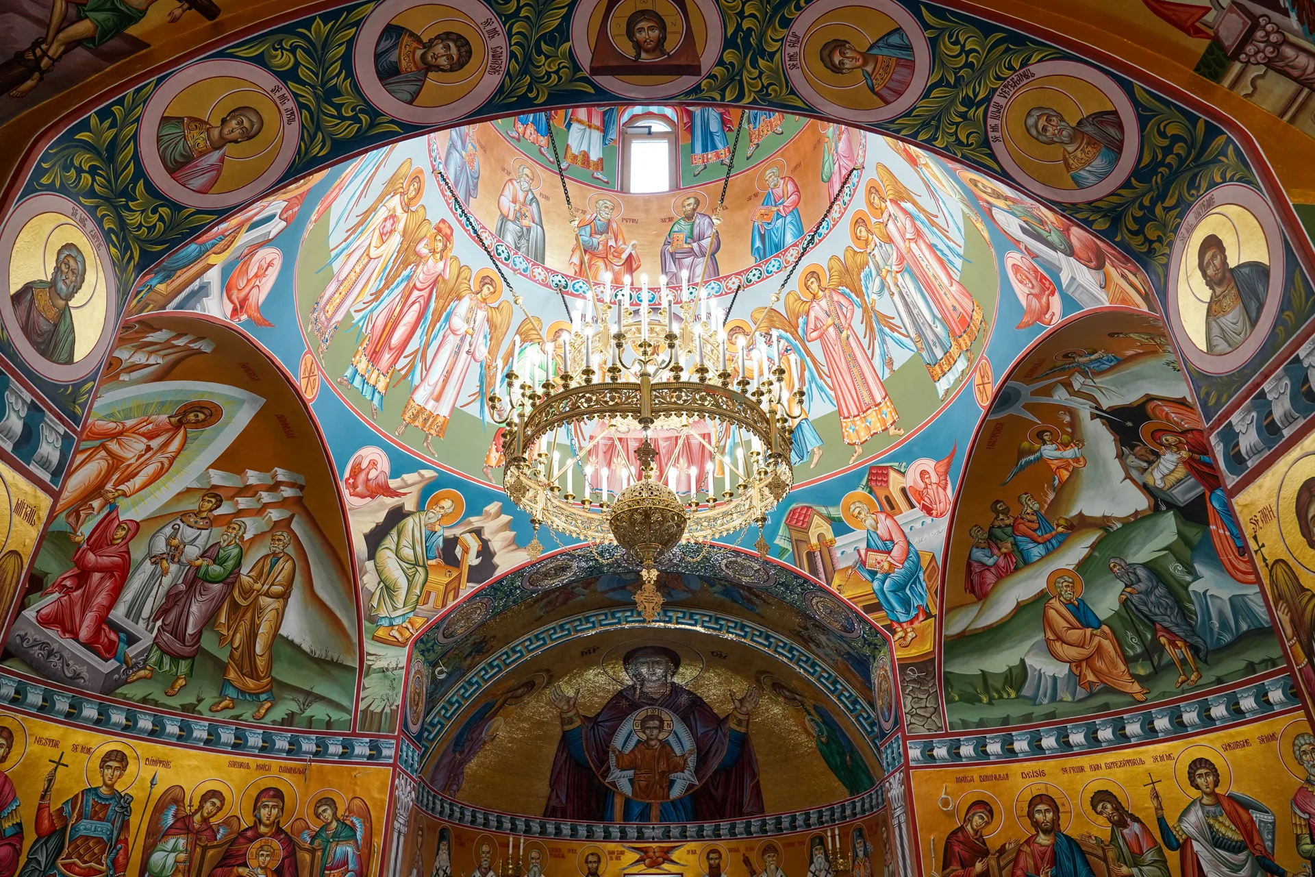 Interiorul bisericii cu fresce bizantine si candelabru